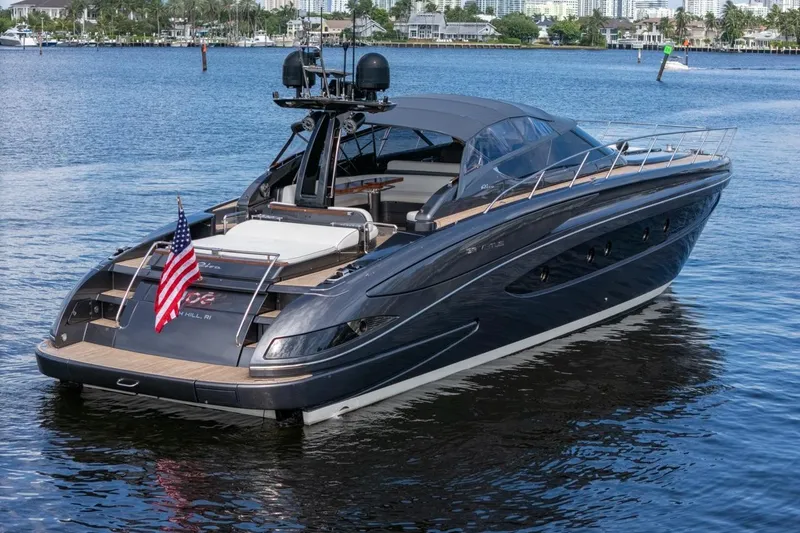 Slide: The Image of Luxury 2015 Riva 63 yacht on calm water, featuring sleek design and American flag. - 11