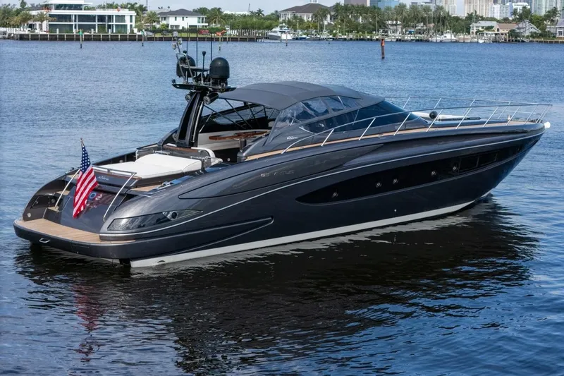 Slide: The Image of Luxury 2015 Riva 63 yacht on calm water with American flag displayed. - 13