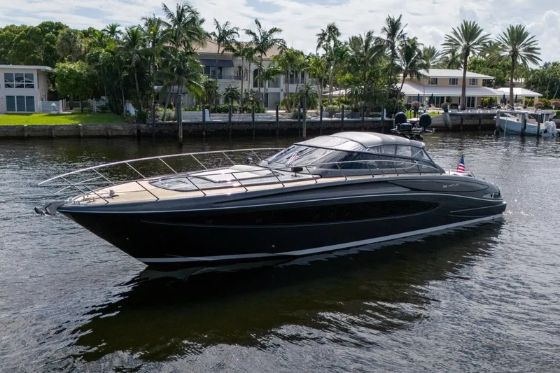 Slide: The Image of Luxurious 2015 Riva 63 yacht cruising on a scenic waterway with palm trees. - 2