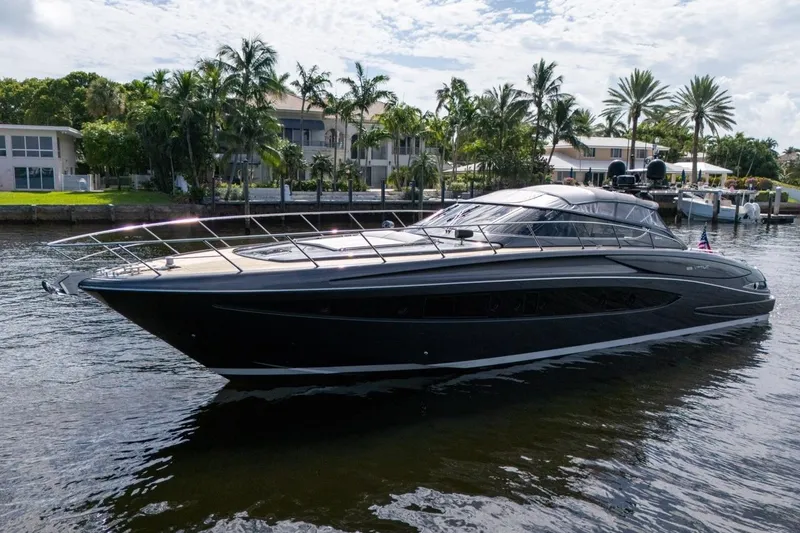 Slide: The Image of Luxurious 2015 Riva 63 yacht docked by palm trees and waterfront homes. - 3
