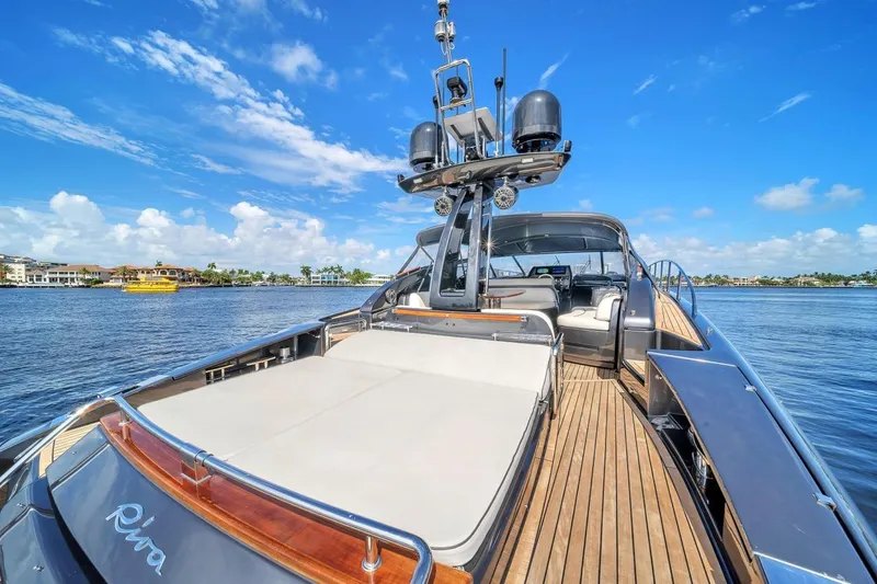 Slide: The Image of Luxurious 2015 Riva 63 yacht on serene water, showcasing sleek design and spacious deck. - 32