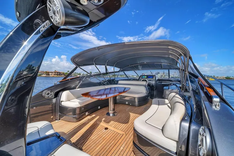 Slide: The Image of Luxurious 2015 Riva 63 yacht interior with elegant seating and wooden deck under clear blue sky. - 33