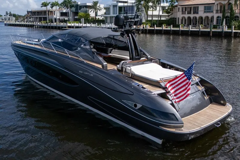 Slide: The Image of Luxurious 2015 Riva 63 yacht with American flag, docked near waterfront homes. - 5