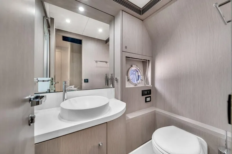 Slide: The Image of Luxurious bathroom interior of 2015 Riva 63 yacht with modern fixtures and porthole window. - 63