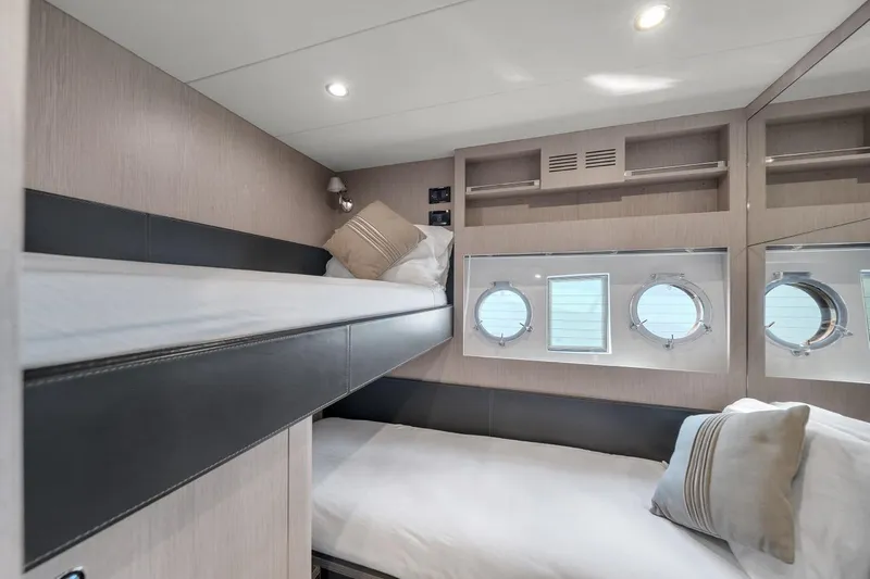 Slide: The Image of Luxurious 2015 Riva 63 yacht cabin with bunk beds and porthole windows. - 65