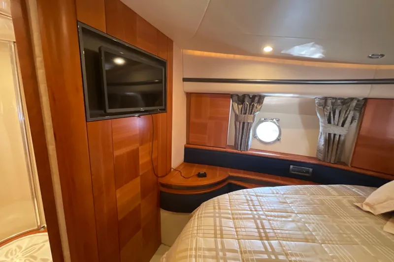 Slide: The Image of Luxurious 2005 Azimut Fly 50 yacht cabin with TV, wood paneling, and porthole window. - 25