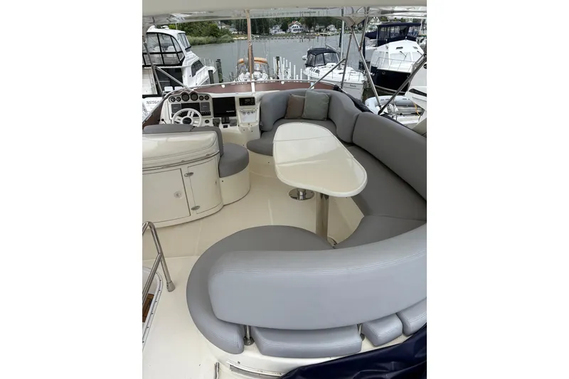 Slide: The Image of 2005 Azimut Fly 50 yacht interior with gray seating and helm, docked at marina. - 31