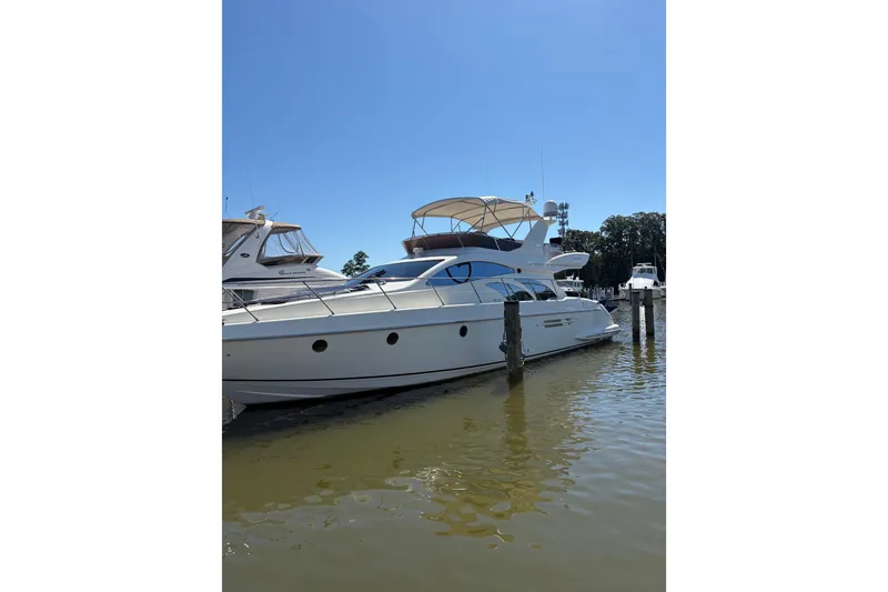 Slide: The Image of 2005 Azimut Fly 50 yacht docked in a marina under clear blue skies. - 41