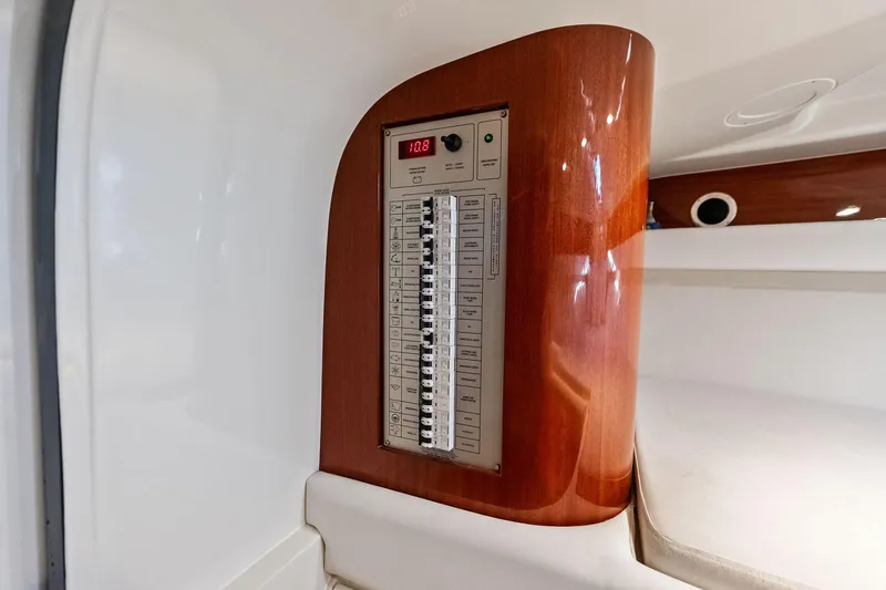 Slide: The Image of Electrical panel inside 2013 Riva 33 Aquariva boat, featuring wood finish and modern controls. - 21