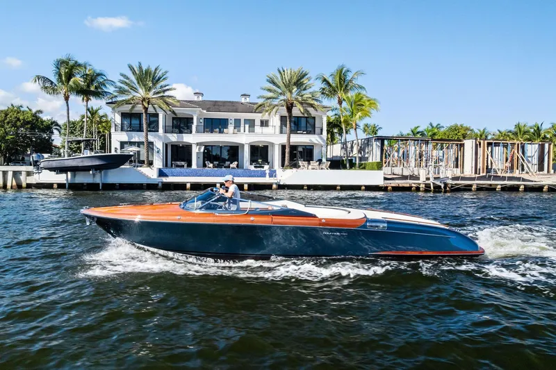 Slide: The Image of 2013 Riva 33 Aquariva cruising on water near luxury waterfront home with palm trees. - 25