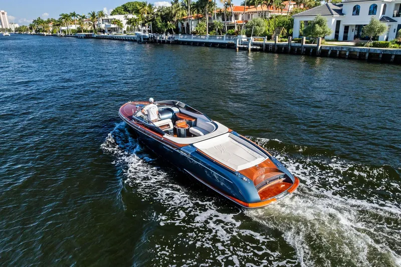 Slide: The Image of 2013 Riva 33 Aquariva luxury boat cruising on a scenic waterway. - 23
