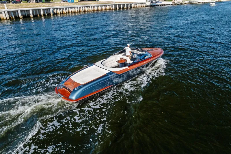 Slide: The Image of 2013 Riva 33 Aquariva luxury boat cruising on a serene waterway. - 24