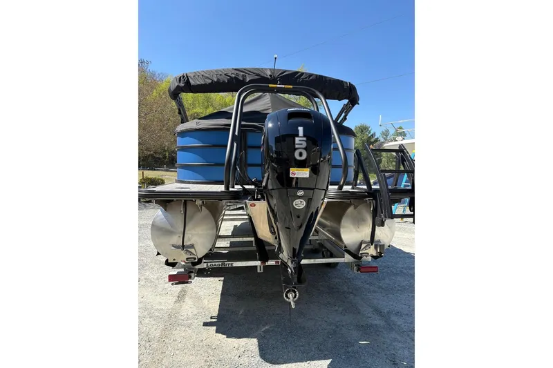 Slide: The Image of 2026 Bentley Pontoons Legacy 223 Navigator with powerful outboard motor, parked outdoors. - 10