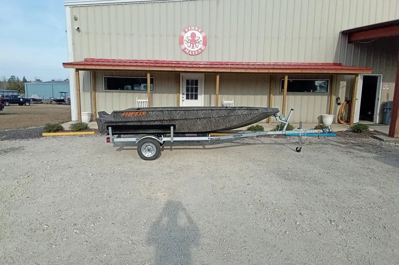 Slide: The Image of 2026 Alweld 1552 Invader boat on trailer outside a metal building. - 3