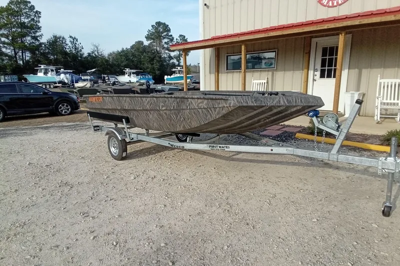 Slide: The Image of 2026 Alweld 1552 Invader boat on trailer outside a building, surrounded by parked vehicles. - 4