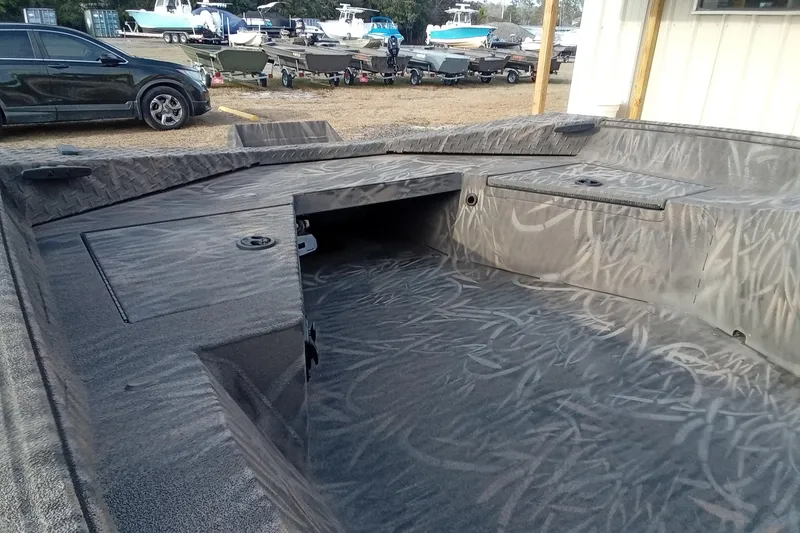 Slide: The Image of 2026 Alweld 1552 Invader boat interior with textured flooring, parked outdoors. - 9