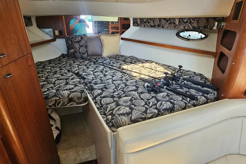 Slide: The Image of 2001 Tiara Yachts 3100 Open cabin with patterned bedding and fishing rods. - 21