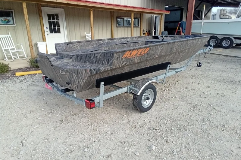 Slide: The Image of 2026 Alweld 1652 Invader boat on trailer, parked outside a building. - 10