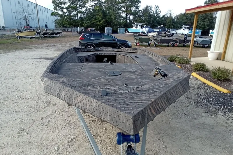 Slide: The Image of 2026 Alweld 1652 Invader boat on trailer, parked outdoors near other boats. - 5