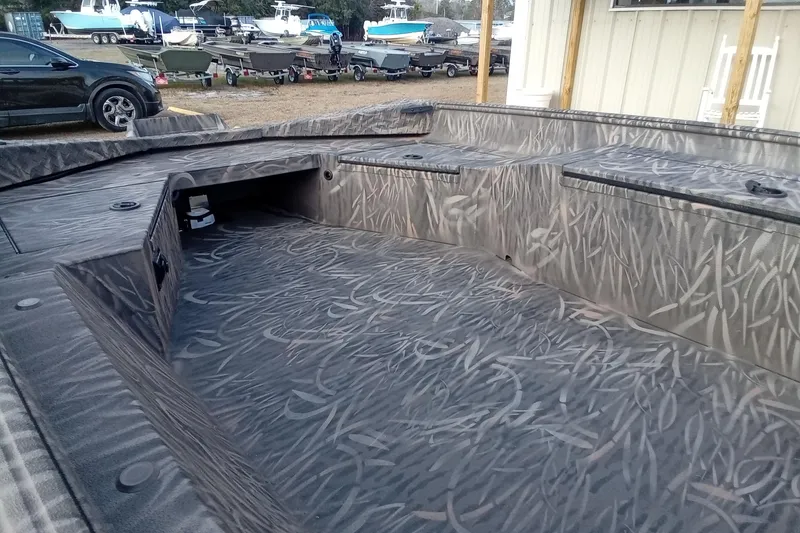 Slide: The Image of 2026 Alweld 1652 Invader boat interior with camouflage pattern, parked near other boats. - 8