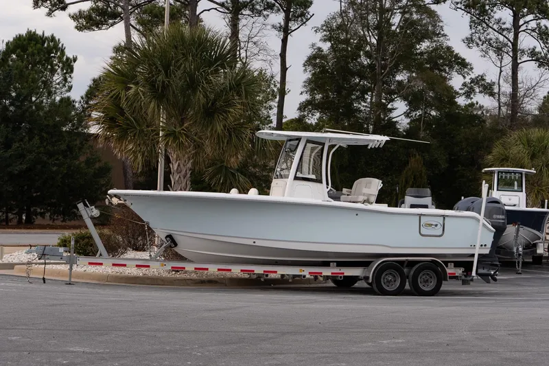 The Image of 2023 Sea Hunt Gamefish 25 boat on trailer, parked near palm trees. - 1