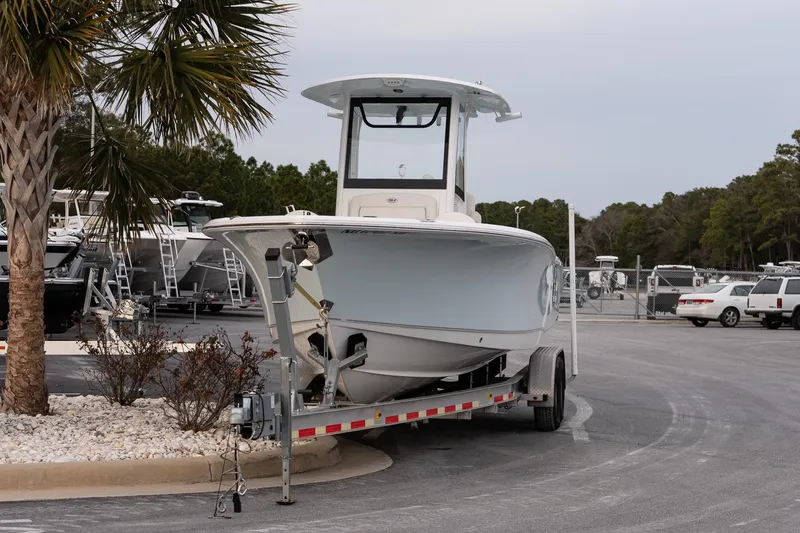 Slide: The Image of 2023 Sea Hunt Gamefish 25 boat on trailer in a marina parking lot. - 2