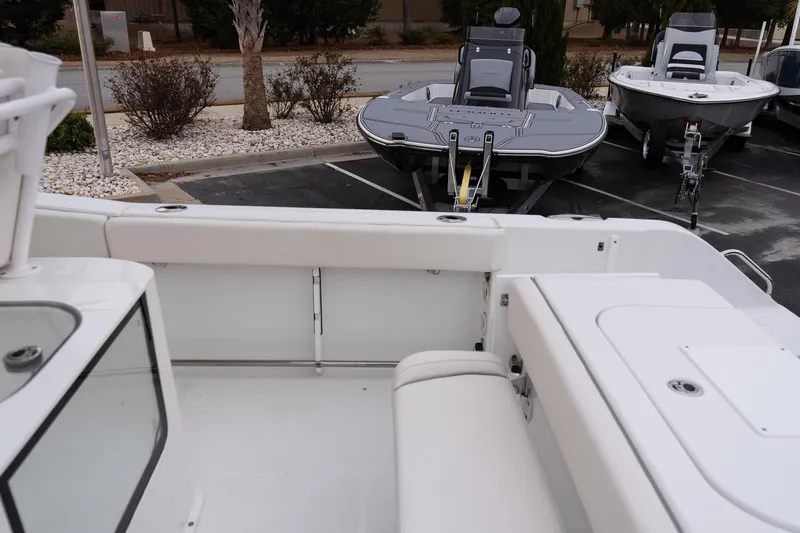 Slide: The Image of 2023 Sea Hunt Gamefish 25 boat interior with seating and storage, parked outdoors. - 9