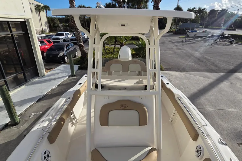 Slide: The Image of 2018 Key West 219 FS boat interior with seating and console, parked outdoors. - 11