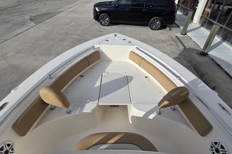 Slide: The Image of 2018 Key West 219 FS boat interior with tan seating and table, parked near a black SUV. - 17