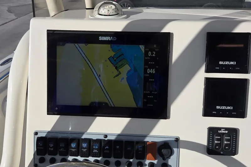Slide: The Image of 2018 Key West 219 FS boat dashboard with Simrad navigation display and Suzuki controls. - 19
