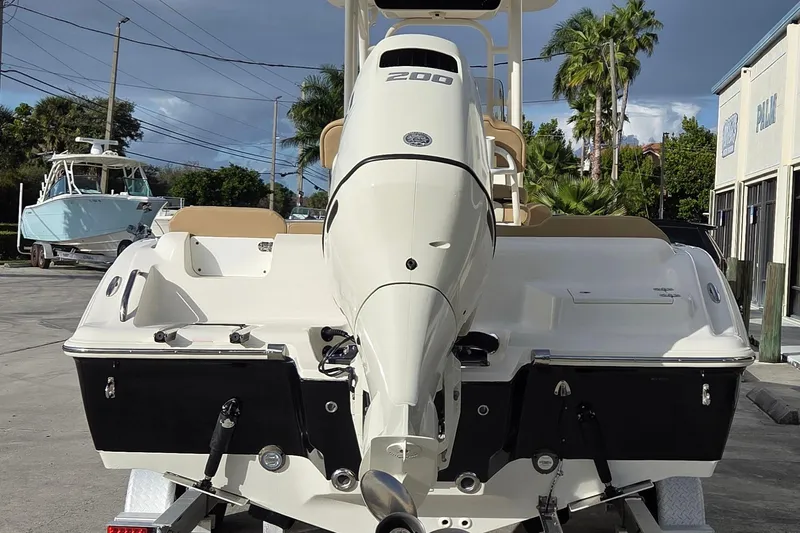 Slide: The Image of 2018 Key West 219 FS boat with powerful outboard motor, parked outdoors. - 20
