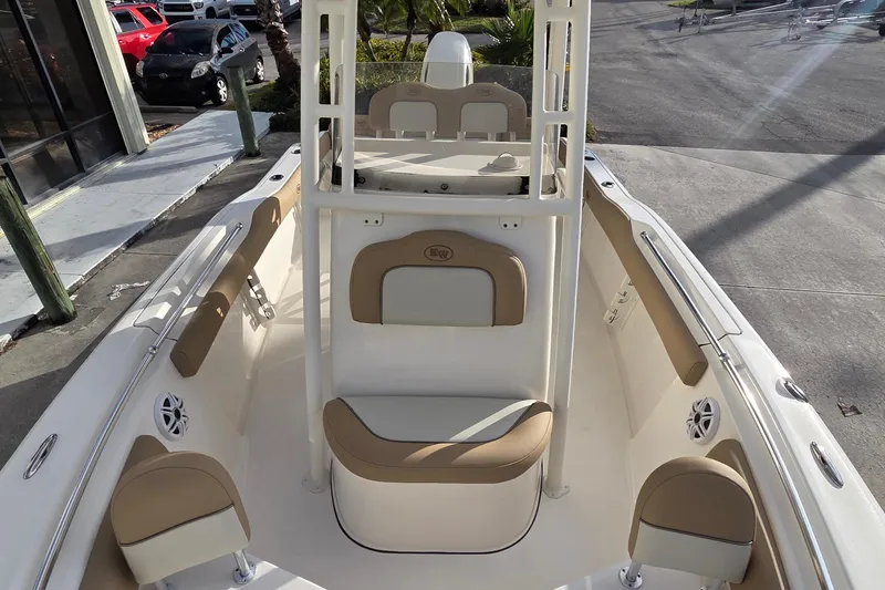 Slide: The Image of 2018 Key West 219 FS boat interior with tan and white seating, docked outdoors. - 4