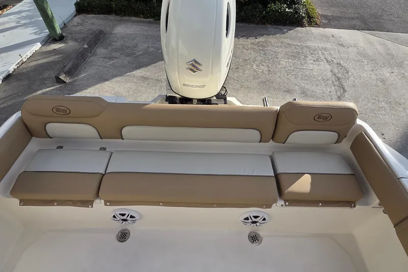 Slide: The Image of 2018 Key West 219 FS boat interior with cushioned seating and Suzuki outboard motor. - 6