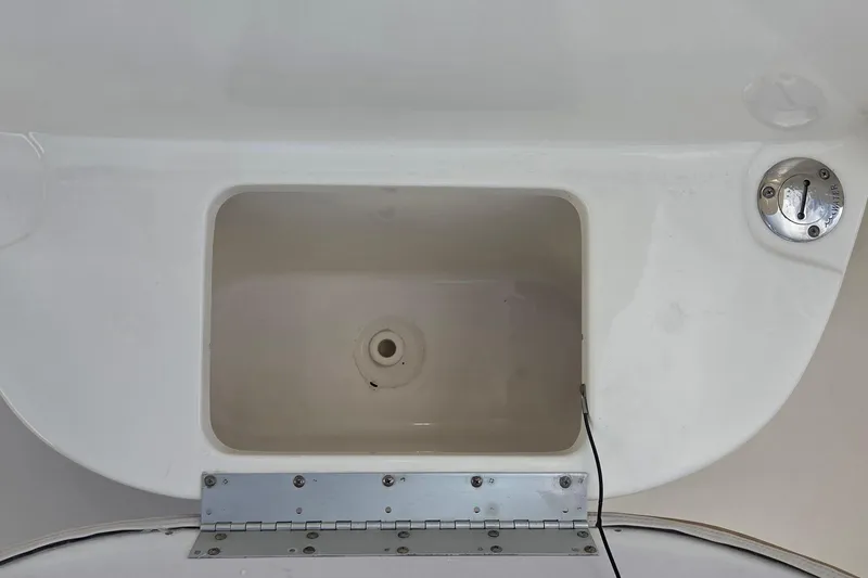 Slide: The Image of 2018 Key West 219 FS boat storage compartment with drain and latch. - 8