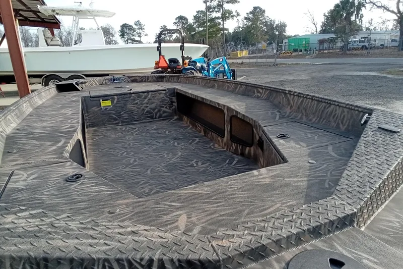 Slide: The Image of 2026 Alweld 1756 Invader boat with camo pattern, parked outdoors. - 13