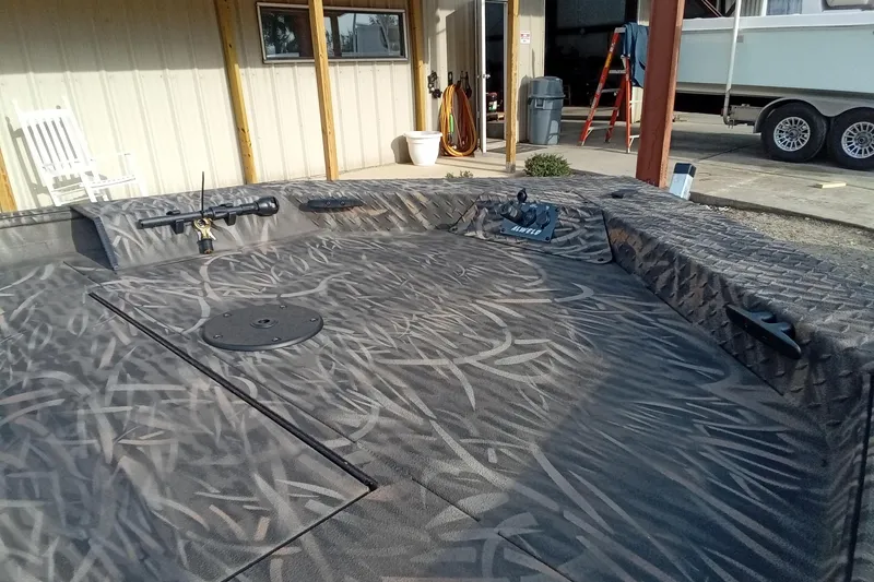 Slide: The Image of 2026 Alweld 1756 Invader boat with camo pattern, docked near a building. - 7