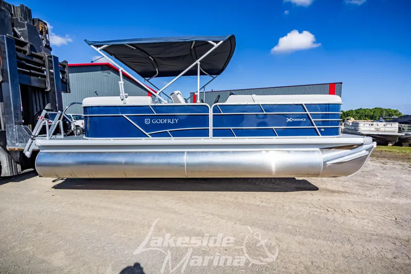 Slide: The Image of 2024 Godfrey Sweetwater 2286 SBX pontoon boat with blue exterior, displayed at Lakeside Marina. - 2