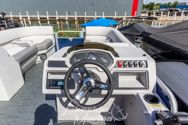Slide: The Image of 2024 Godfrey Sweetwater 2286 SBX boat dashboard with steering wheel and controls at Lakeside Marina. - 22