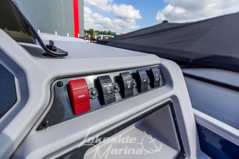 Slide: The Image of Control panel of 2024 Godfrey Sweetwater 2286 SBX boat with switches and horn button. - 25