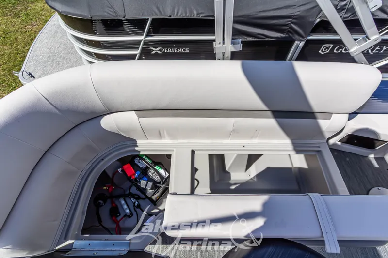 Slide: The Image of 2024 Godfrey Sweetwater 2286 SBX pontoon boat with open storage compartment and visible battery. - 32