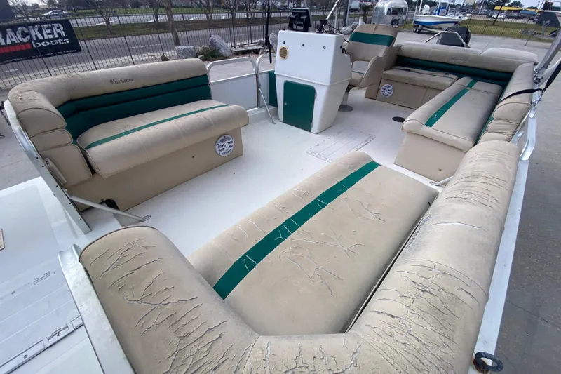 Slide: The Image of 1994 Hurricane FunDeck 226 boat interior with worn beige and green seating. - 13
