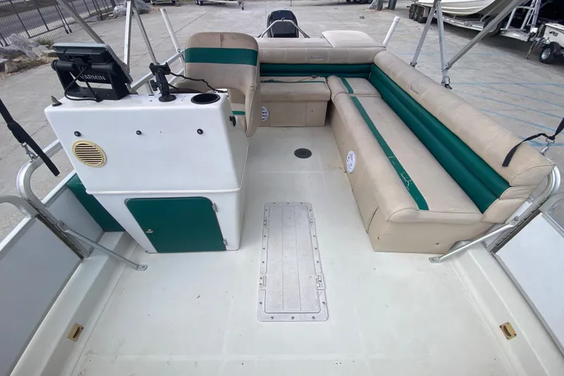 Slide: The Image of 1994 Hurricane FunDeck 226 boat interior with beige and green seating, steering console, and deck. - 15