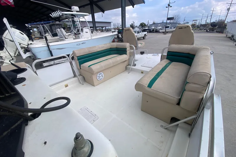Slide: The Image of 1994 Hurricane FunDeck 226 boat interior with beige and green seating, docked outdoors. - 16