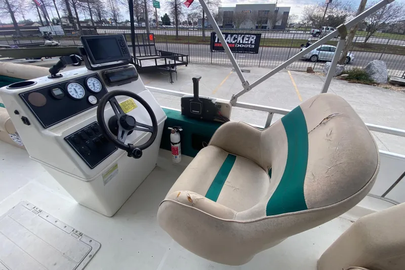 Slide: The Image of 1994 Hurricane FunDeck 226 boat cockpit with steering wheel and worn captain's chair. - 18