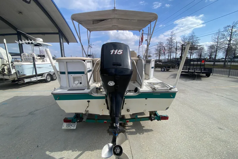 Slide: The Image of 1994 Hurricane FunDeck 226 boat with 115 HP outboard motor, parked outdoors. - 5