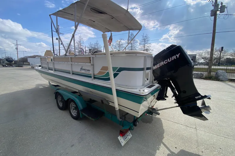 Slide: The Image of 1994 Hurricane FunDeck 226 boat with Mercury outboard motor on trailer, parked outdoors. - 6