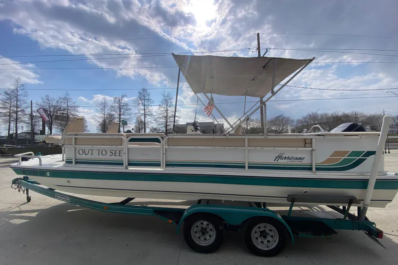 Slide: The Image of 1994 Hurricane FunDeck 226 boat on trailer under cloudy sky. - 7
