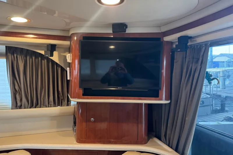 Slide: The Image of Interior of 2003 Sea Ray 480 Sedan Bridge with mounted TV and elegant wood finish. - 10