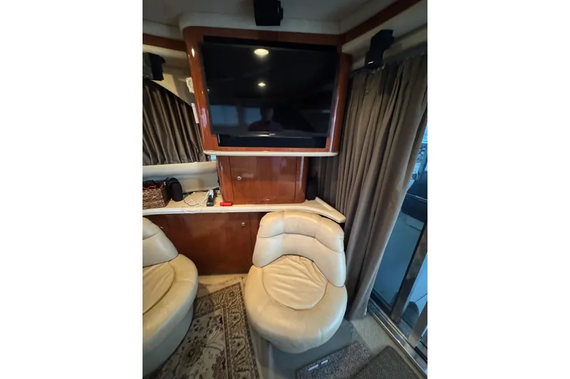 Slide: The Image of Interior of 2003 Sea Ray 480 Sedan Bridge with leather seating and mounted TV. - 12