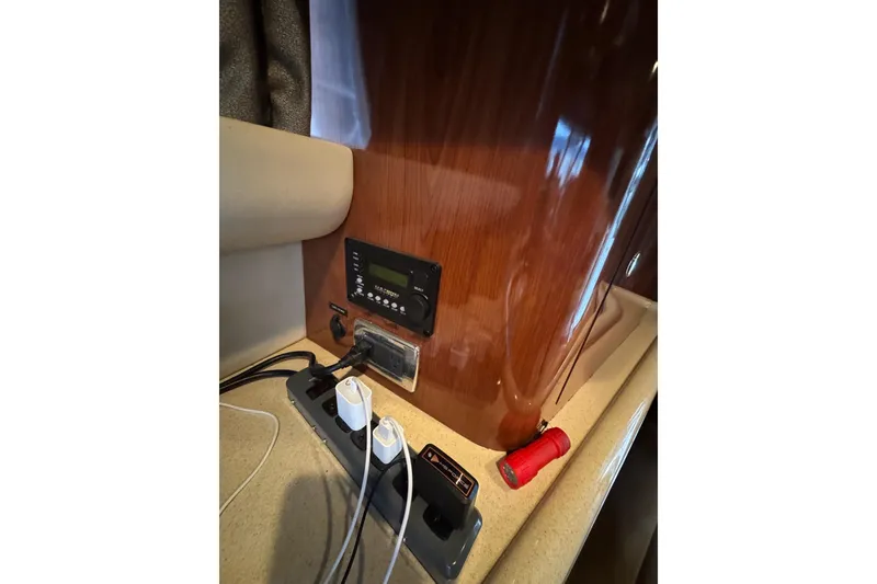 Slide: The Image of Control panel and power strip inside 2003 Sea Ray 480 Sedan Bridge yacht cabin. - 13